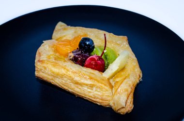 Siyah tabakta meyveli pasta.