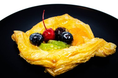 Siyah tabakta meyveli pasta.