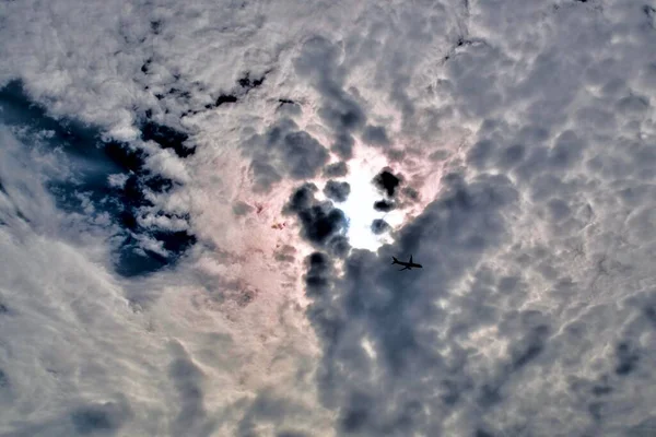 飞机在明亮的天空和云彩之上 — 图库照片