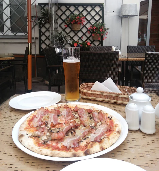 Pizza with a glass of beer in a cozy retro cafe