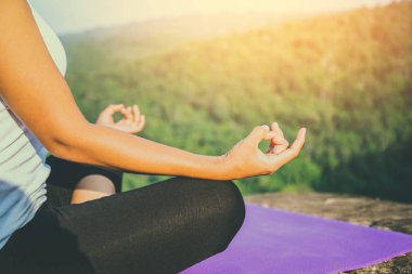 Asya kadınları tatilde rahatlayın. Yogada oynayın. Dağ kaya uçurumunda. Tayland dağ ormanlarının doğası
