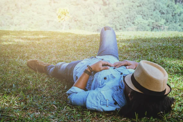 Asian man travel relax in the holiday. Sleep relax on the lawn