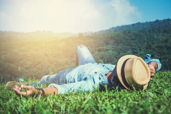 Asijský muž se v prázdni cestuje. Spánek Relaxujte na trávníku — Stock fotografie