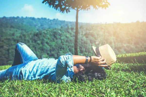 Hombre asiático viajar relajarse en las vacaciones. Sueño relajarse en el césped — Foto de Stock