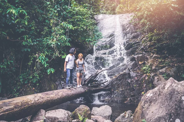 Muži a ženy cestují. Muži a ženy páry Asie cestovatelů cestování přírodou lesy, hory, vodopády — Stock fotografie