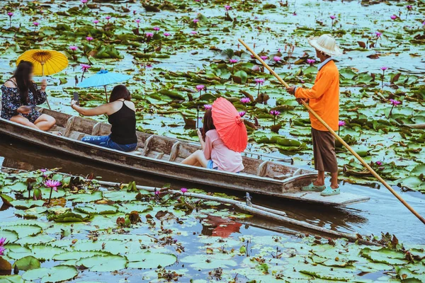 游客坐在划船上 看沼泽中的莲花 — 图库照片