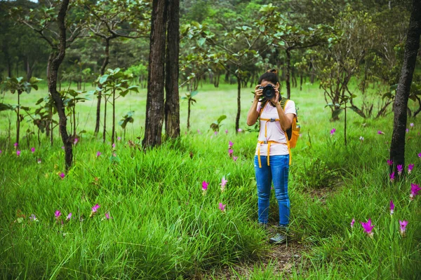 Cestování asijskou ženou přírodou. Cestování je v klidu. Fotografování okurky z květů. — Stock fotografie