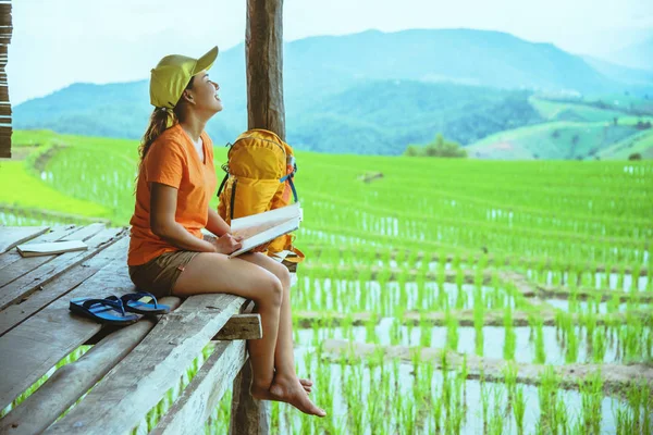 Asiatische Frau reisen die Natur. Beim Aufklappen eines Schirmschleuderrucksacks auf dem Feld. Blick auf das Feld auf dem Berg im Sommer. Thailand — Stockfoto