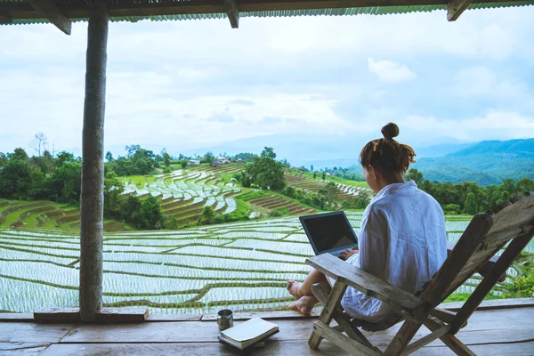 Asyalı kadın seyahat doğa. Seyahat rahatlayın. bir dizüstü bilgisayar ile tatil balkon da iş oturup. Yaz aylarında Moutain üzerinde alan görünümü. seyahat Tayland.