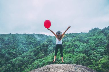 Asyalı kadınlar tatilde rahatlarlar. Kayalık bir üzerinde Stand Jump 
