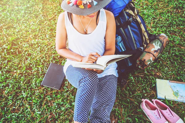 Asiatische Frauen entspannen sich im Urlaub. sitzen und Bücher über Grünland im Park lesen. Bildung, lesen Sie ein Buch, Buch, schreiben Sie eine Notiz, Tagebuch, Natur, Outdoor, Urlaub, Sport, Bewegung, entspannen, Reisen Thailand, Sommer. — Stockfoto