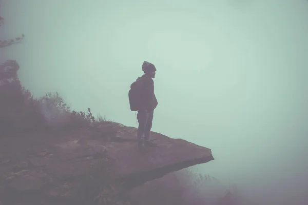 The man travel stands on a cliff on a rich forest mountain. Asia — Stock Photo, Image