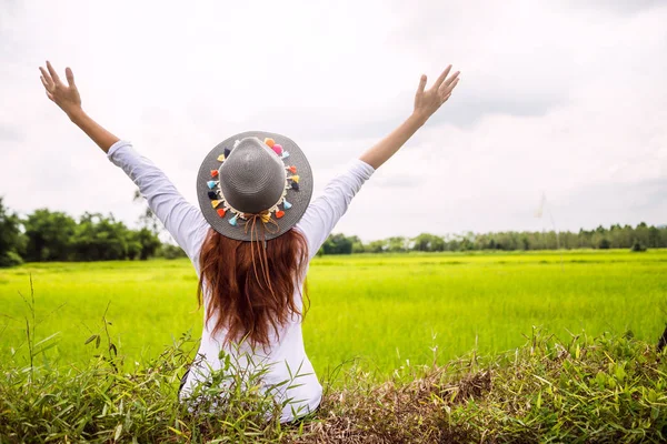 Las mujeres asiáticas viajan relajarse en las vacaciones. en un pastizal verde . — Foto de Stock