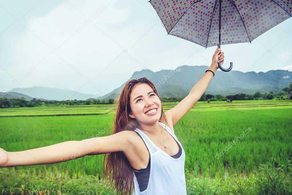 Asian women travel relax in the holiday. Women stand in rain 