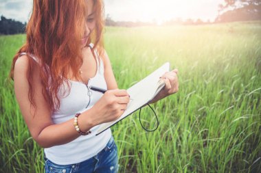 Kadınlar notlar yazar. Doğa yolları, dağlar, ormanlar. Yazar. Asi