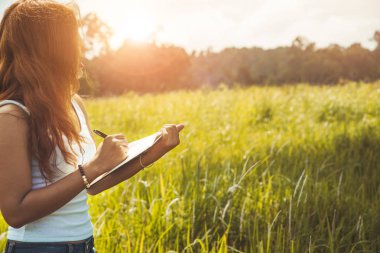 Kadınlar notlar yazar. Doğa yolları, dağlar, ormanlar. Yazar. Asi