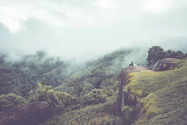 Women travel sit on a cliff on a rich forest mountain. Asia Trop — Stock Photo, Image