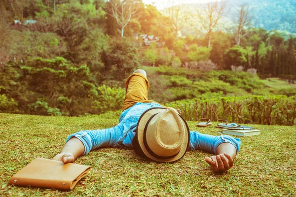 Hombre asiático viajar naturaleza. Relájate. dormir en el césped en el — Foto de Stock