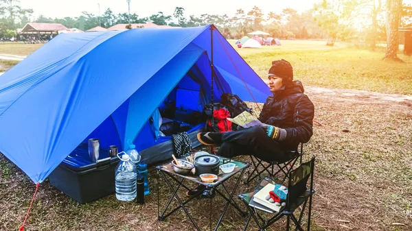 Aziatische man reizen ontspannen kamperen in de vakantie. kamperen op de berg. zit ontspannen bekijk kaart reizen op de stoel. Thailand — Stockfoto