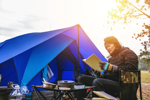 Asyalı erkek seyahati tatilde kamp yapma rahatlığı. Dağda kamp yapmak. Otur ve rahatla. Sandalyede kitap oku. Tayland — Stok fotoğraf