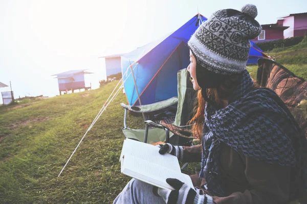 As mulheres asiáticas viajam relaxar nas férias. acampar na Montanha. sente-se leia um livro sobre a cadeira. Tailândia — Fotografia de Stock