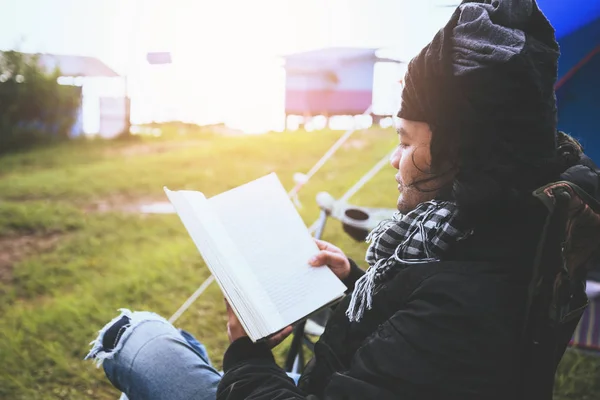 Asiatische Männer reisen entspannt in den Urlaub. junger Mann reist Natur campen auf dem Berg. sitzend eine Notiz auf den Stuhl schreiben und ein Buch lesen. camping zelt, camping thailand, bildung, buch, notiz schreiben, tagebuch. — Stockfoto