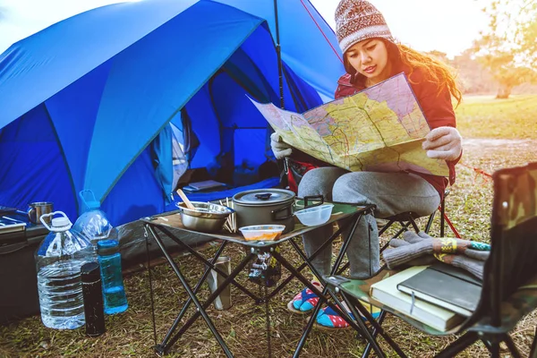 As mulheres asiáticas viajam relaxar acampar no feriado. Acampamento turístico durante a noite na montanha. barraca de acampamento, camping Tailândia, educação, ler um livro, livro, diário. As mulheres viajam sentadas, relaxam, vêem o mapa, viajam na cadeira. As mulheres viajam pelo campo. Comer alimentos — Fotografia de Stock