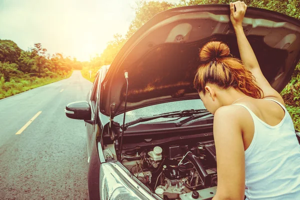 亚洲妇女的汽车是破碎的道路。打开发动机舱盖，检查发动机。年轻女性在中间旅行、开车、旅行、浪费汽车. — 图库照片