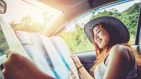 Asian women travel relax in the holiday. Driving a travel map happy travel. The girl was studying to read map travel. summer, nature, outdoor, holiday, relax, travel Thailand.