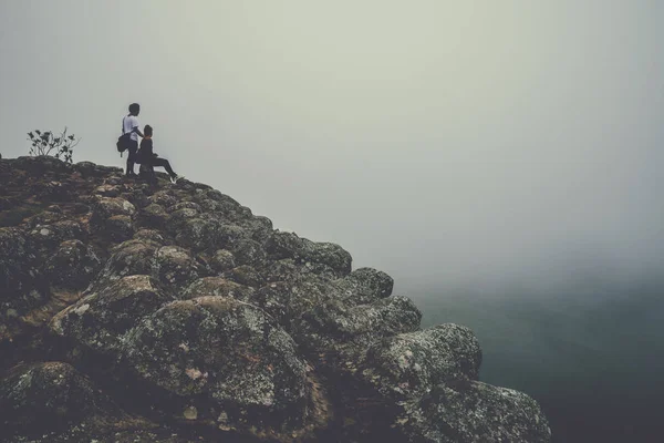 Lover women and men asians travel relax in the holiday. On a cliff on the mountain. Wild nature wood on the mountain. mountain, countryside, forest, nature, outdoor, holiday, relax, travel, summer, travel Thailand. — Stock Photo, Image