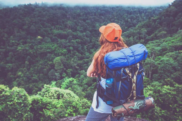 アジアの女性は休日にリラックス旅行します。山の上に立ってる岩の多い崖の上に山の自然なタッチ霧の風景を立つ。旅行タイ. — ストック写真