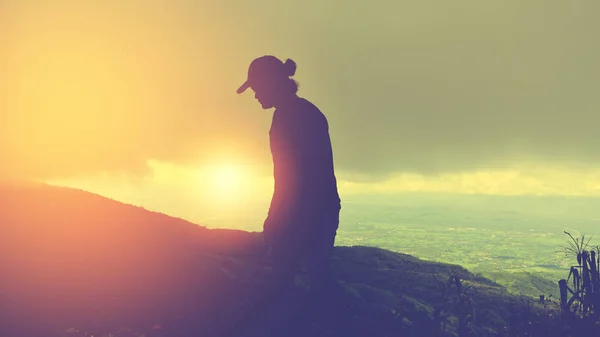 Homem asiático viajar relaxar nas férias.De pé mãos sobre falésias na montanha. Céu noturno ao pôr-do-sol. É uma silhueta. Tailândia . — Fotografia de Stock