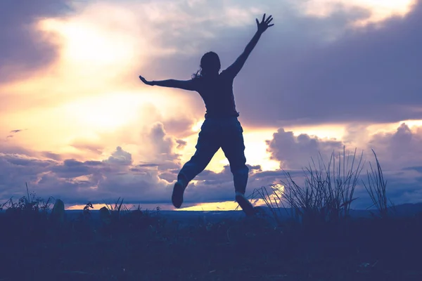 Asian women travel relax in the holiday. Jump on the mountain Evening sky At sunset. Is a silhouette. Thailand