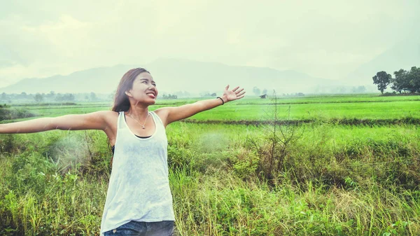 Asiatische Frauen reisen entspannt in den Urlaub. aufstehen, um Regen zu empfangen. auf dem Reisfeld auf dem Land. Reisfeld, Landschaft, Wald, Natur, im Freien, Urlaub, entspannen, Reisen, Sommer, Reisen Thailand. — Stockfoto