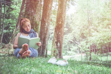 Kadınlar parkta, çam ormanında, tatil ormanında dinlenebilir. eğitim, kitap okumak, kitap.