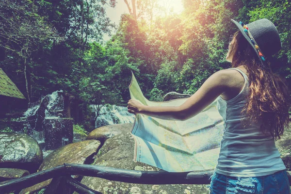 Asian women travel relax in the holiday.Asian woman travel nature walk on the path. Nature Study in the Jungle. mountains, waterfalls, travel Thailand. map