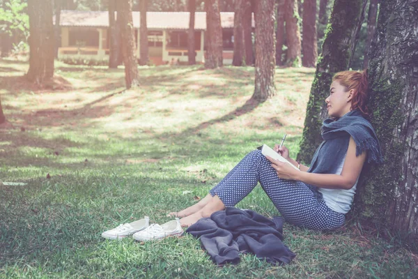 Las mujeres escriben notas Senderos naturales, montañas, bosques, Escritoras, Las mujeres jóvenes disfrutan y disfrutan leyendo. reading, education, book, find knowledge, Escribe una nota, diario, verano — Foto de Stock