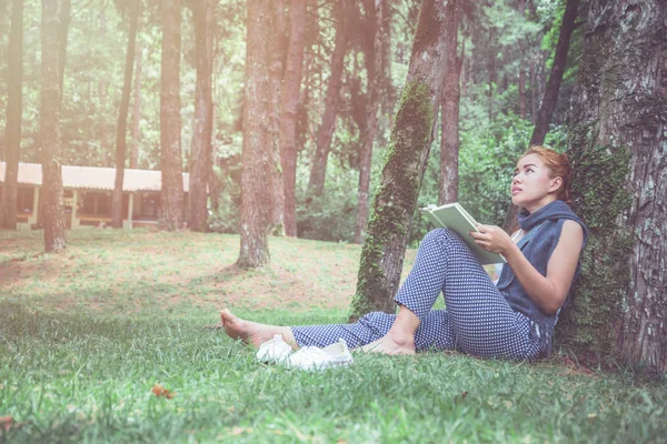 Leer mujeres relajarse en el parque, bosque de pinos, bosque de vacaciones. Las mujeres jóvenes disfrutan y disfrutan leyendo. reading, education, book, find knowledge, Escribir una nota, diario . — Foto de Stock