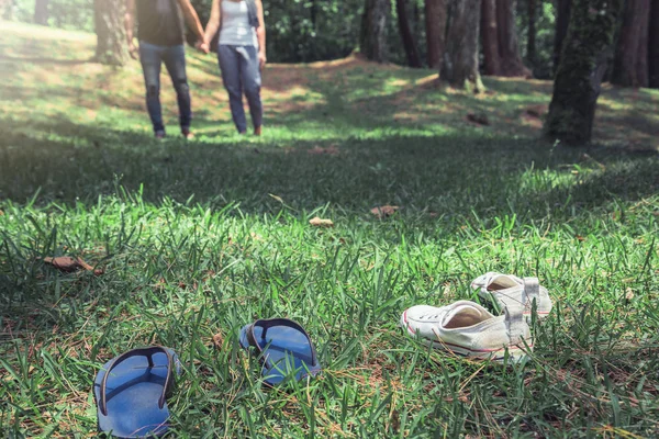 Un par de mujeres con hombres caminando sobre hierba en el jardín natural. Los pies de una pareja caminando sobre la hierba. viajes, naturaleza, relajarse . — Foto de Stock