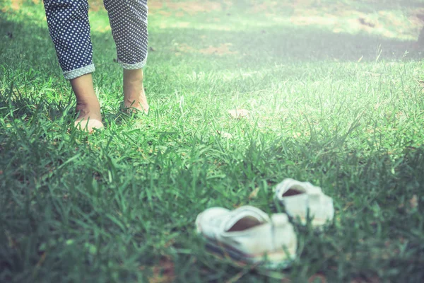 走在绿色草地上的妇女的腿。一个在草地上行走的女孩的脚。旅行， 自然， 放松. — 图库照片