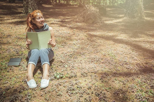 Leer mujeres relajarse en el parque, bosque de pinos, bosque de vacaciones. Las mujeres jóvenes disfrutan y disfrutan leyendo. lectura, educación, libro, encontrar conocimiento . — Foto de Stock