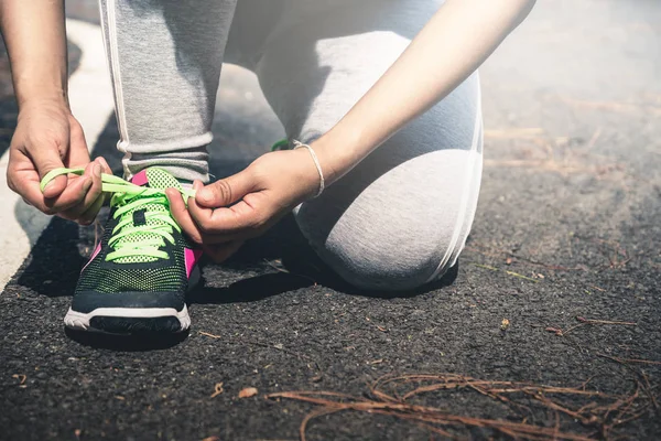 Жінки пов'язують ланцюжок взуття для бігу. На злітно-посадковій смузі. фізичні вправи, бігати, добре здоров'я, розслаблятися . — стокове фото