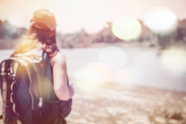 Suddig bild med bokeh kvinnors promenader ryggsäck — Stockfoto