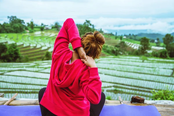 Donna asiatica rilassarsi durante la vacanza. Gioca se lo yoga. Sul balcone paesaggio naturale Field.papongpieng in Thailandia — Foto Stock