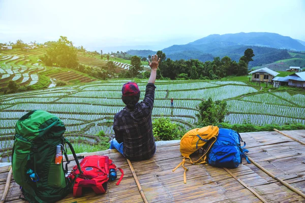 Amante asiático homem asiático mulheres viajar natureza. Caminhando uma foto do campo de arroz e parar fazer uma pausa relaxar na ponte na proibição mae klang luang na estação chuvosa . — Fotografia de Stock