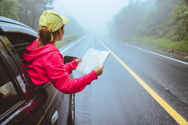 Aziatische vrouwen reizen ontspannen in de vakantie. Reizen met de parkeerplaats. Bekijk kaart voor natuurtochten tijdens het regenseizoen. — Stockfoto