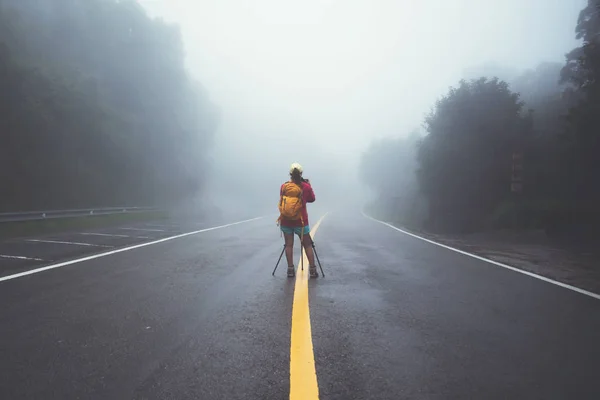 Asian women travel nature. Walk on the road route. Travel nature happily photography. Amid the mist rainy. in the rainy season at Chiangmai in Thailand. — Stock Photo, Image