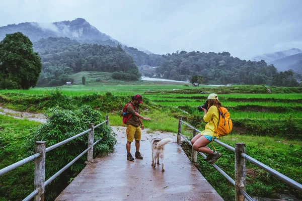 Lover asian man asian women travel nature. Walking a photo the rice field and stop take a break relax on the bridge at  ban mae klang luang in rainy season.