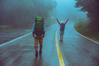 Sevgili Asyalı erkek ve Asyalı kadınlar doğa seyahat. Yol güzergahıüzerinde yürüyün. mutlu bir şekilde doğa seyahat. Sisli yağmurun ortasında. yağmur mevsiminde.