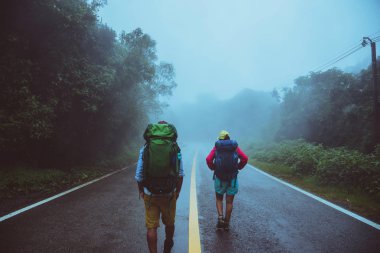 Sevgili Asyalı erkek ve Asyalı kadınlar doğa seyahat. Yol güzergahıüzerinde yürüyün. mutlu bir şekilde doğa seyahat. Sisli yağmurun ortasında. yağmur mevsiminde.